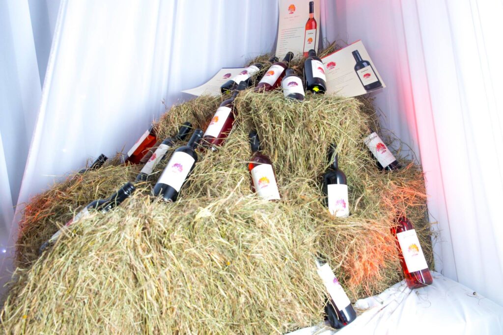 A display of various Leleshwa wines on a haystack