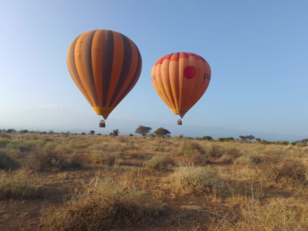 Two airborne hot-air balloons in Amboseli National Park